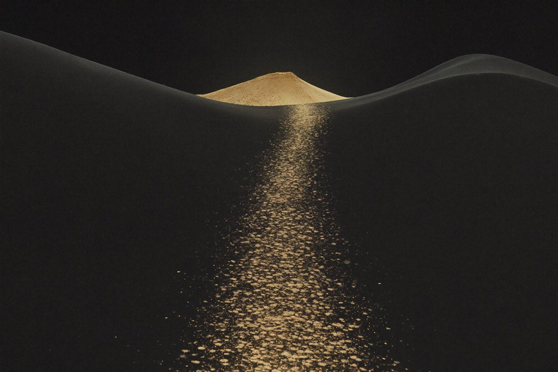 Gold trail to a glowing summit on black — dopamine and motivation