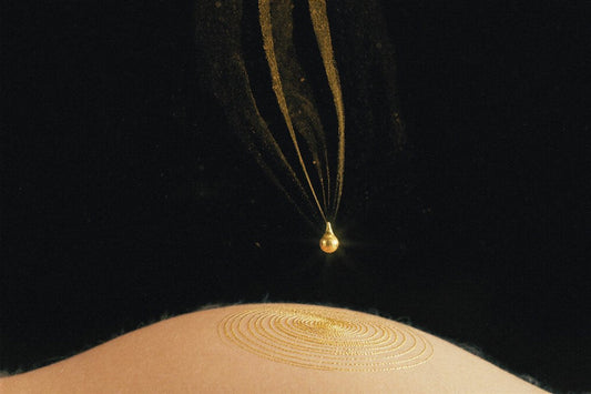 Gold droplet and pulse rings on black — where to apply perfume