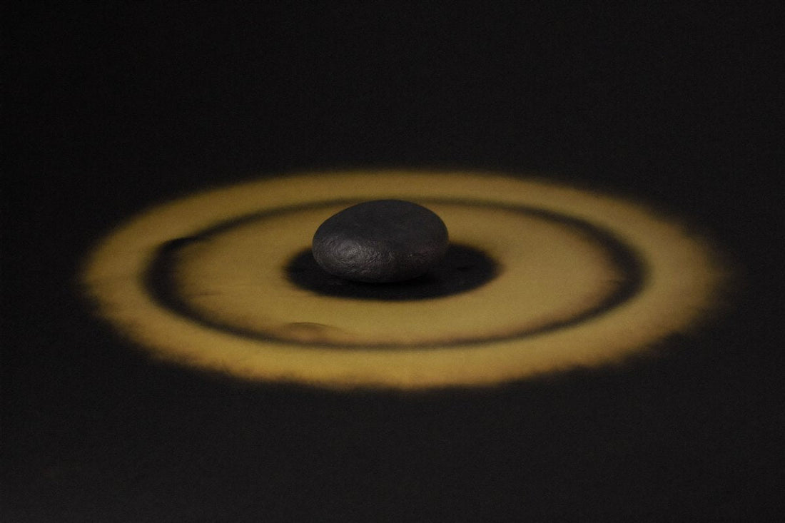A smooth stone ringed by gold light — a distraction-free phone