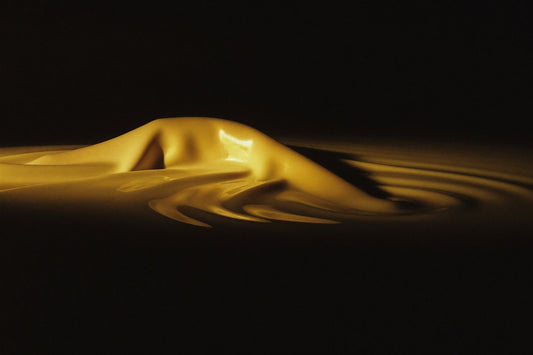 Liquid satin in warm gold light on black — do satin bonnets protect hair