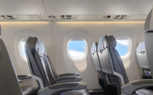 Airplane cabin window with a view of sky and clouds