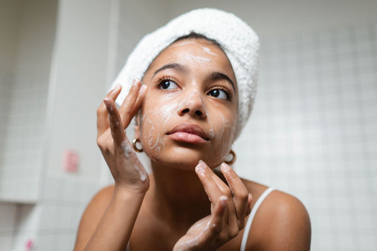 Young woman with fresh skin doing her skincare routine in a bright, modern bathroom